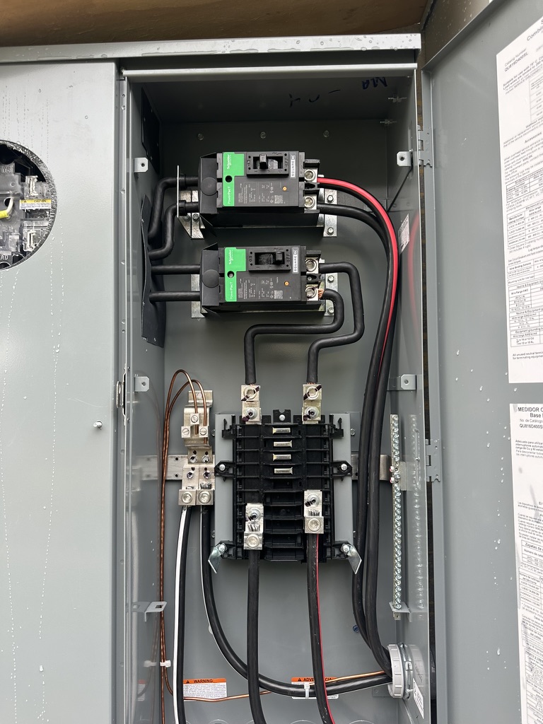 Outdoor disconnect panel installed on a Southwest Florida home showing main breakers required by NEC 230.85