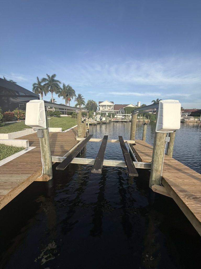 Both boat lift motor covers on their pilings over a canal boat lift