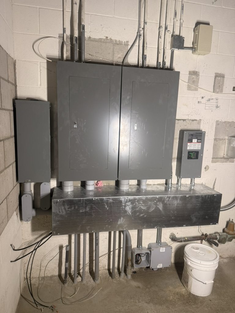 New Square D panelboards, disconnect and wireway in a commercial electrical room on Fort Myers Beach