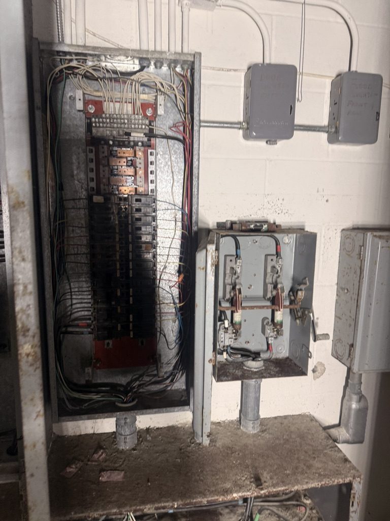 Close-up of the damaged panelboard and disconnect