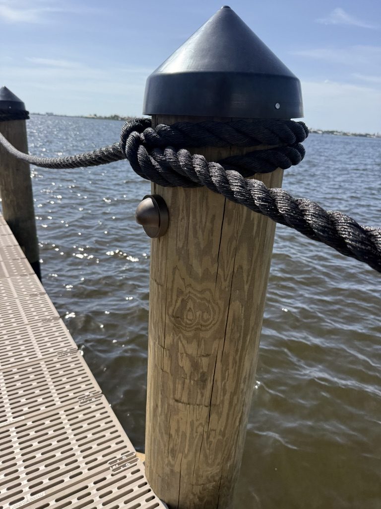 Low-voltage light on a dock piling with the rope railing