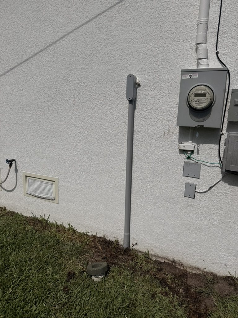 Exterior conduit with an LB conduit body beside the electric meter, feeding the sub panel through to the garage
