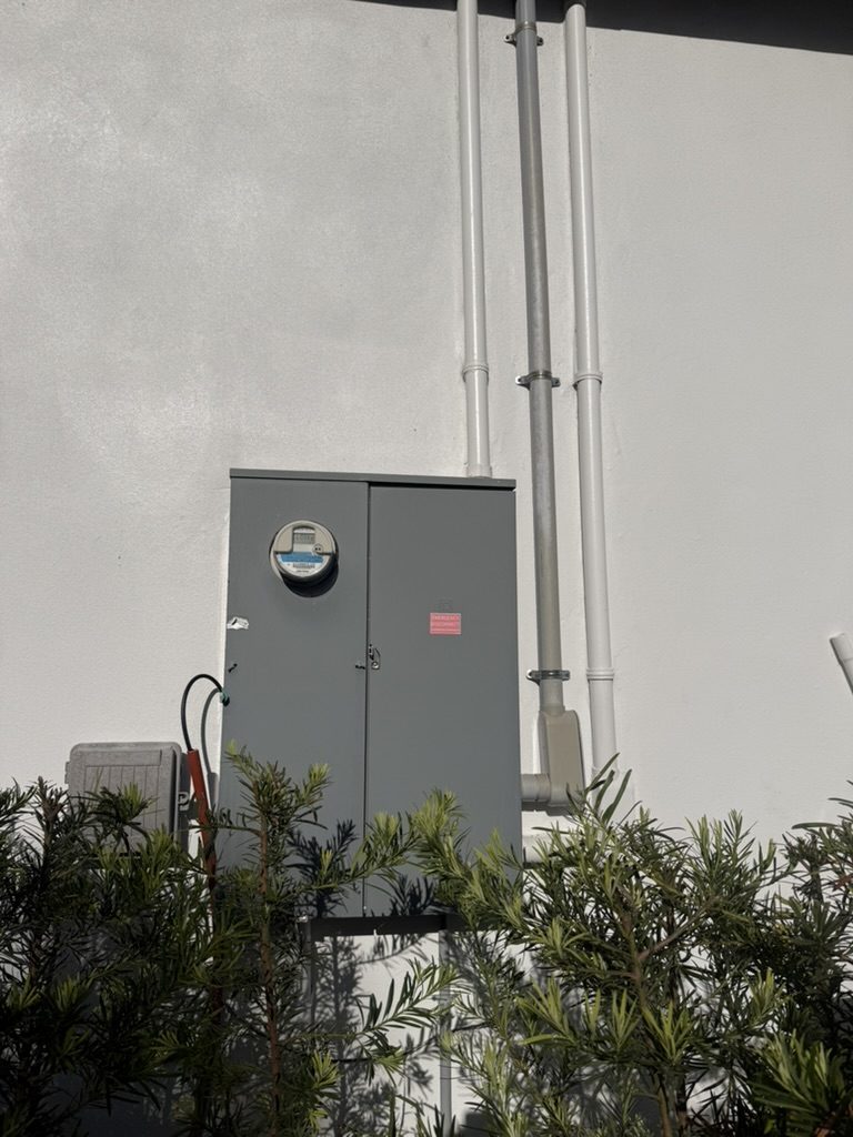 Exterior meter main before the work, wide view with conduit above