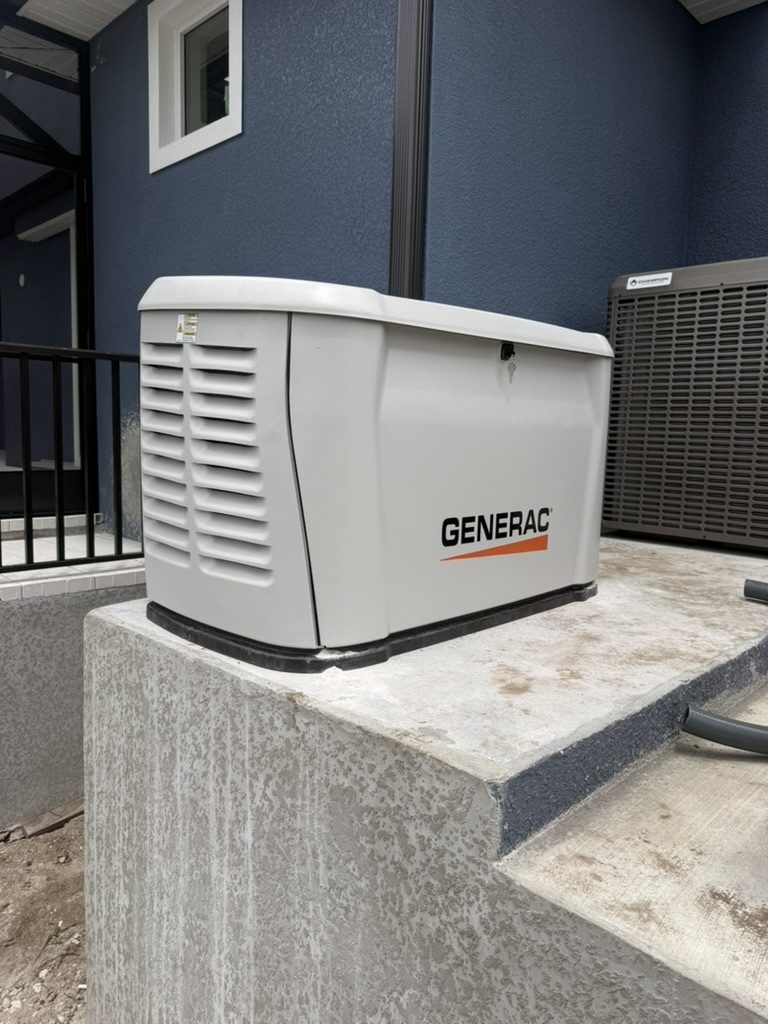 Generac 26 kW standby generator on a raised concrete pad at the back of the home, next to the air conditioner