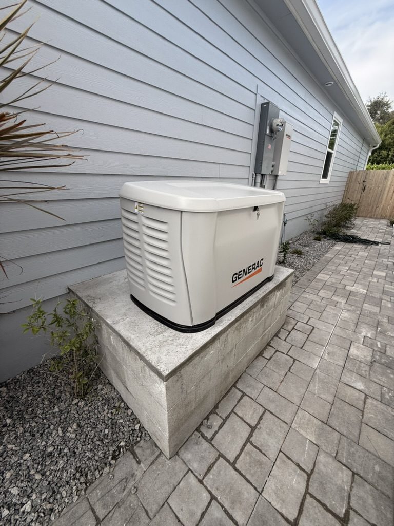 Generac 28 kW generator on a raised concrete pad beside a lap-siding home in Fort Myers