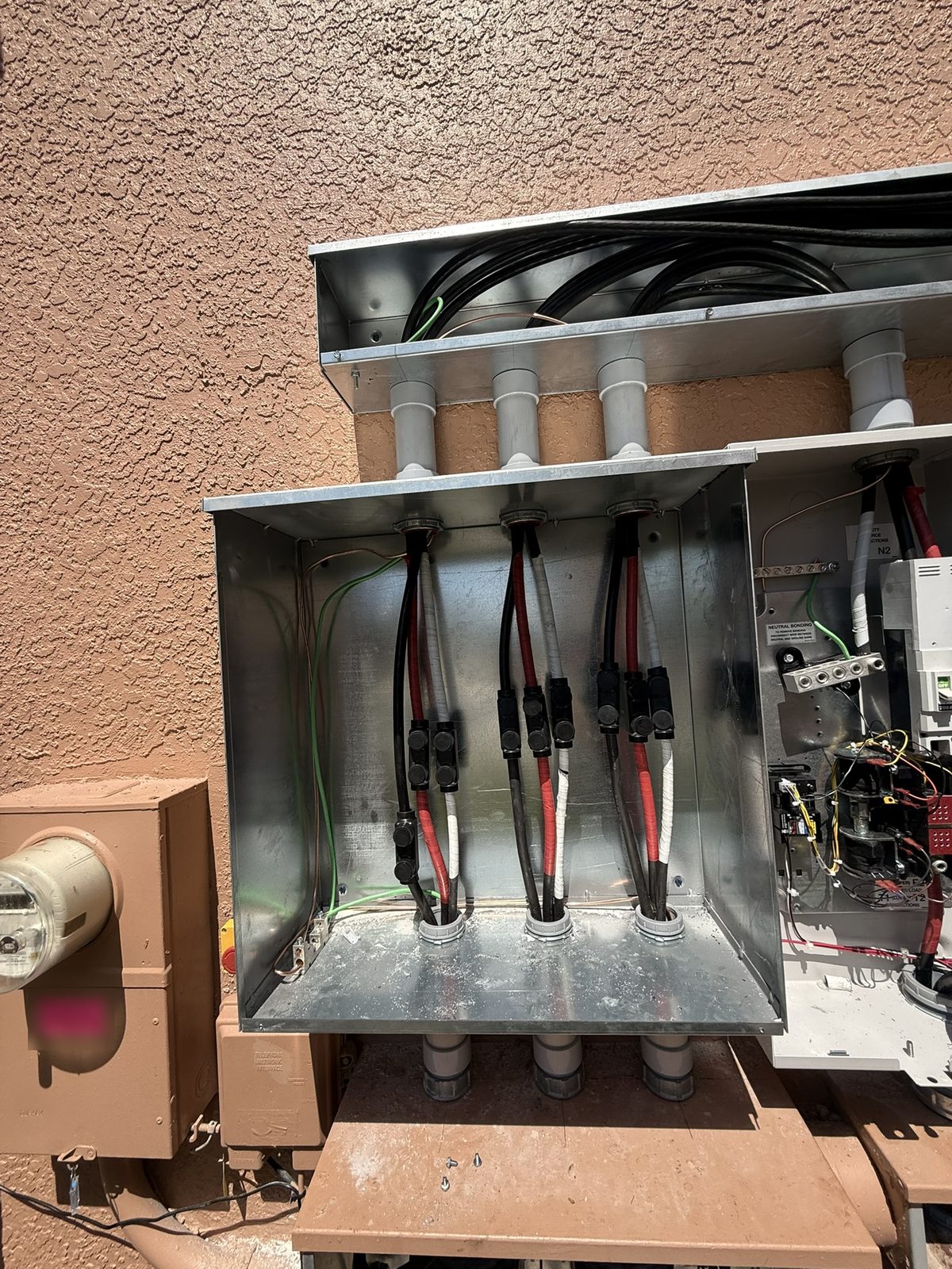 Utility service conductors extended with Polaris taps inside the 24 by 24 inch box, opened only to show the work
