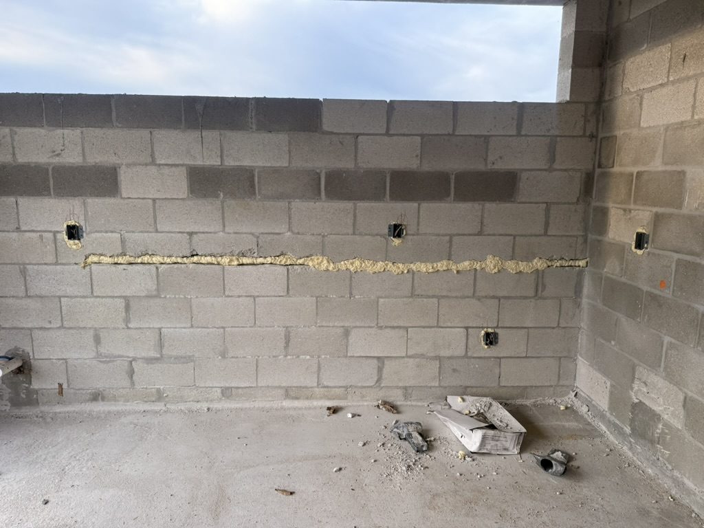 Device boxes in a concrete block wall with a foam-filled horizontal chase
