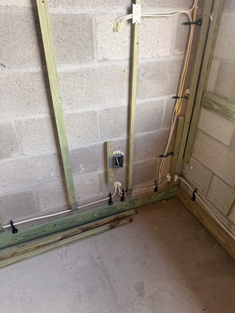 Cables secured with cable ties along the bottom of a block wall corner