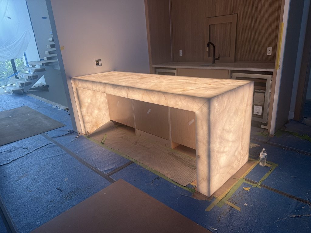 Translucent stone countertop glowing from the LED sheets, floor covering still down