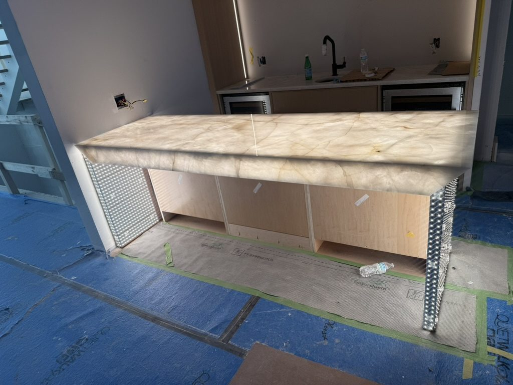 Translucent stone countertop lit from behind, with Aspect LED sheets visible on the side panels
