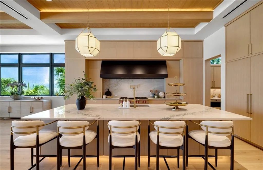 Finished kitchen island with LED-lit wood ceiling beams and toe kick lighting