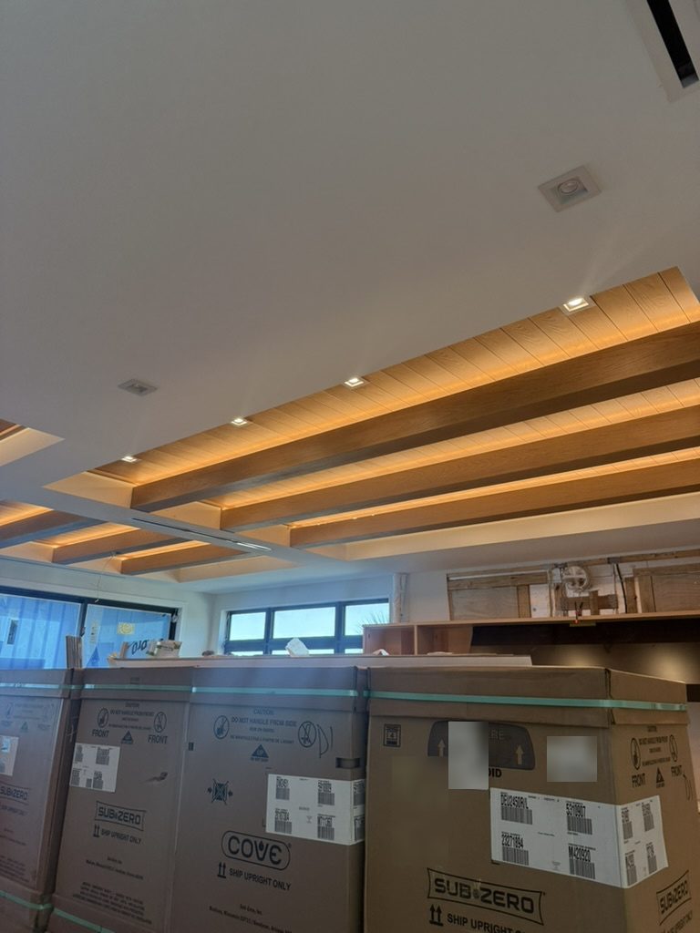 LED tape lit on wood ceiling beams with recessed lights while the home was still under construction
