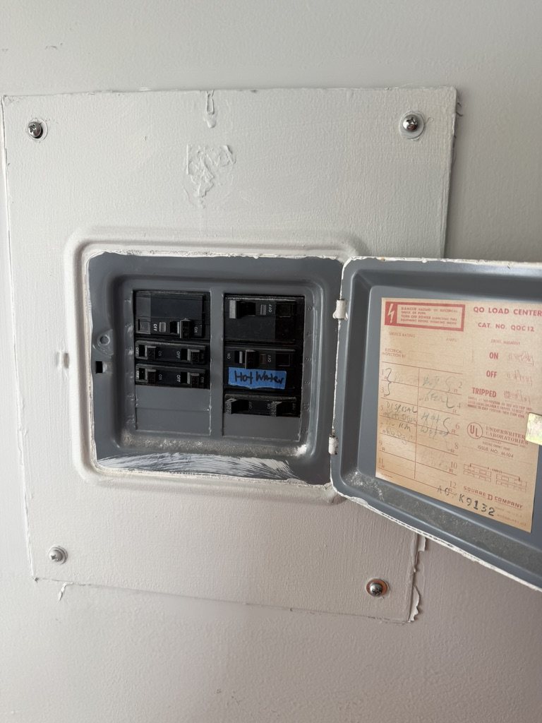 Older Square D QO load center in a condominium unit with the door open